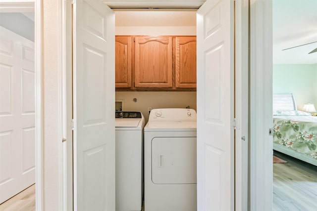 washroom with ceiling fan, light hardwood / wood-style flooring, independent washer and dryer, and cabinets