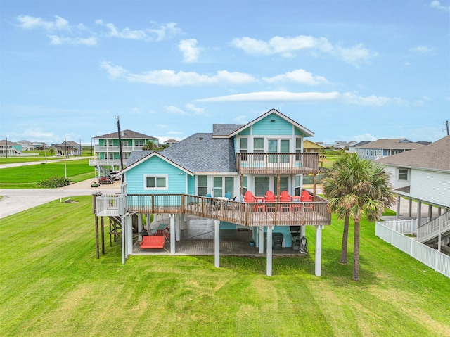 rear view of property featuring a wooden deck, a patio area, a balcony, and a yard