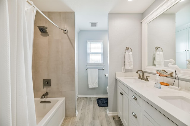 full bathroom with toilet, hardwood / wood-style flooring, vanity, and shower / bath combo with shower curtain