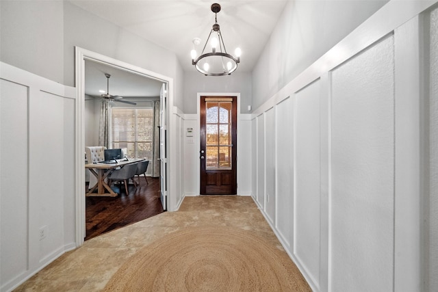 foyer with ceiling fan with notable chandelier