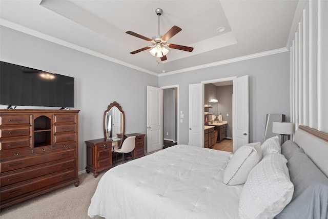 carpeted bedroom with ceiling fan, ensuite bathroom, crown molding, and a tray ceiling