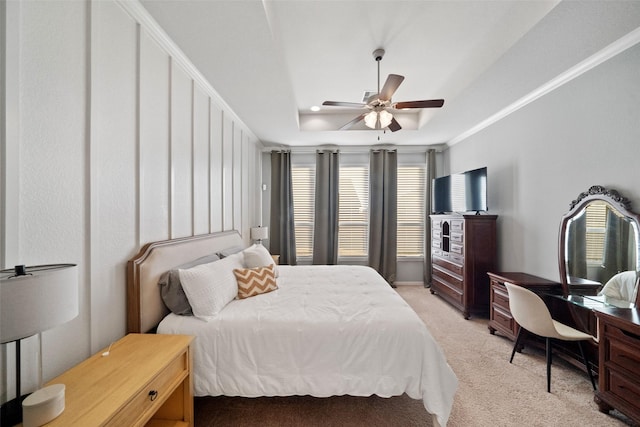 carpeted bedroom featuring ceiling fan, a tray ceiling, and ornamental molding