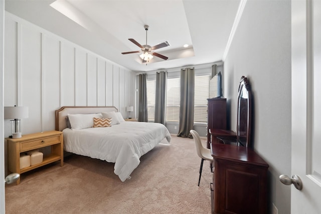 bedroom featuring ceiling fan, light colored carpet, crown molding, and a raised ceiling