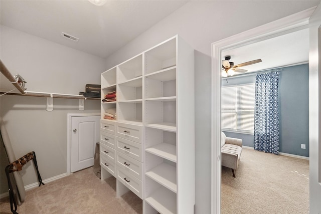 spacious closet with light carpet and ceiling fan