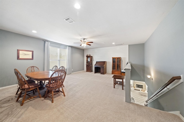 carpeted dining area with ceiling fan