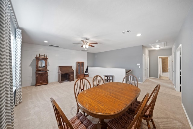 dining area with ceiling fan and light carpet