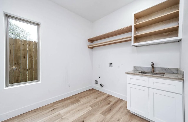 laundry room featuring light hardwood / wood-style floors, sink, hookup for a washing machine, hookup for an electric dryer, and cabinets