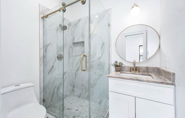 bathroom featuring toilet, vanity, and a shower with door