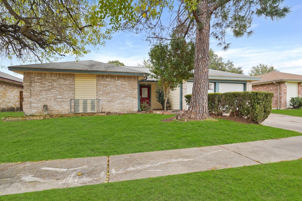 single story home featuring a garage and a front yard