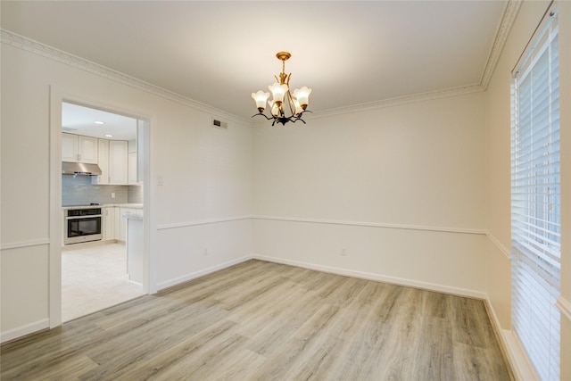 spare room with crown molding, light hardwood / wood-style floors, and a notable chandelier