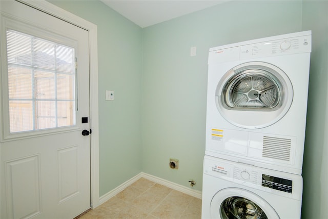 clothes washing area featuring stacked washer / dryer