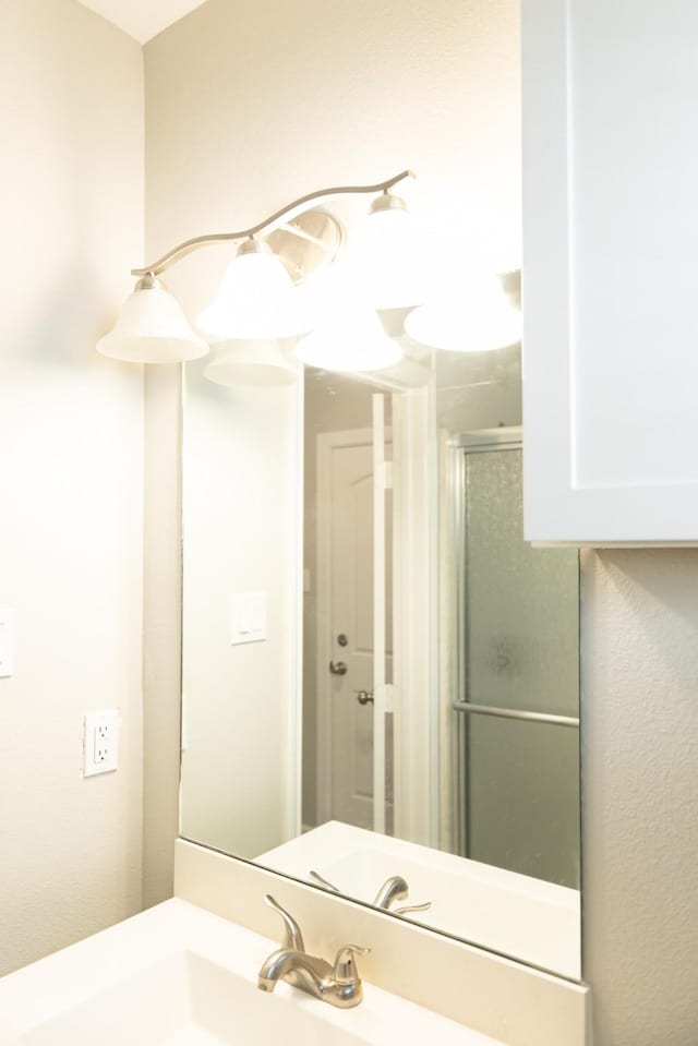 bathroom featuring walk in shower and vanity