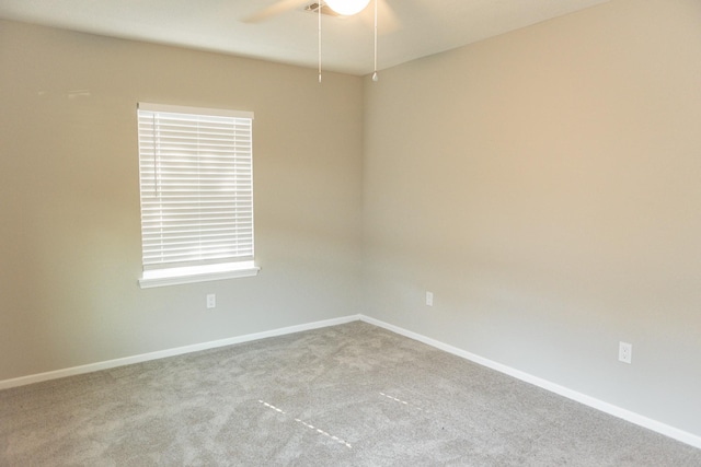 carpeted spare room featuring ceiling fan