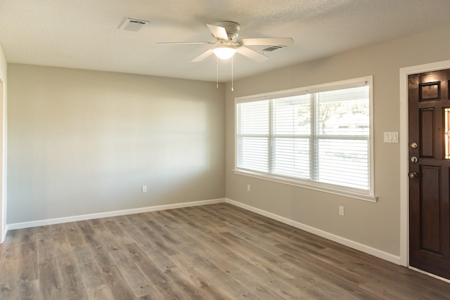 interior space with ceiling fan, a textured ceiling, and hardwood / wood-style floors