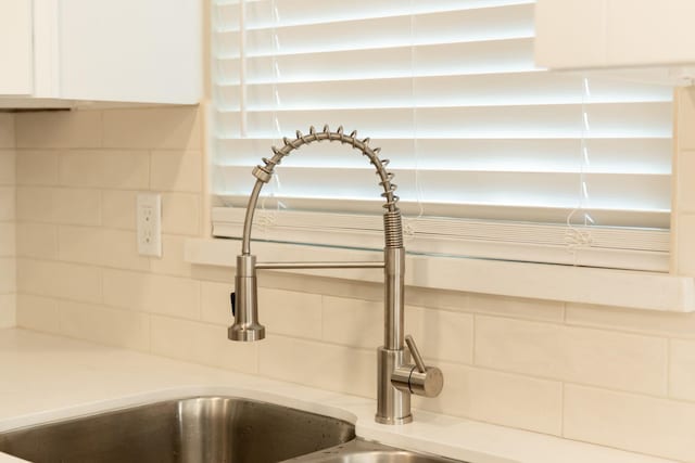 room details featuring white cabinetry and decorative backsplash