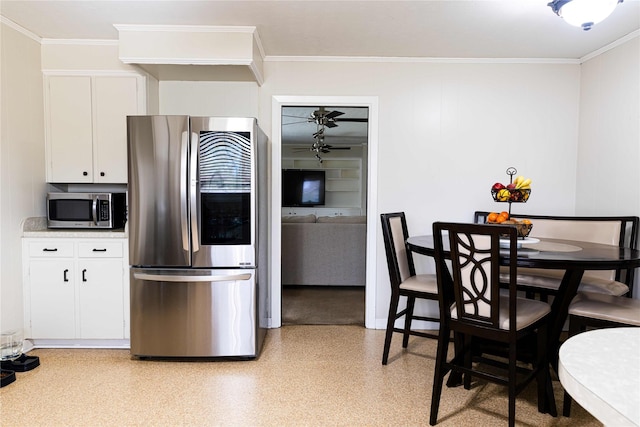 kitchen featuring stainless steel appliances, ornamental molding, and white cabinetry