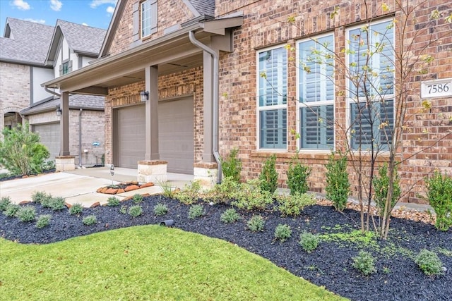 view of property exterior featuring brick siding, concrete driveway, a garage, and roof with shingles