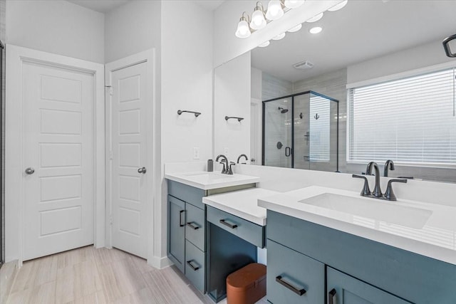 bathroom featuring vanity, a shower stall, and visible vents