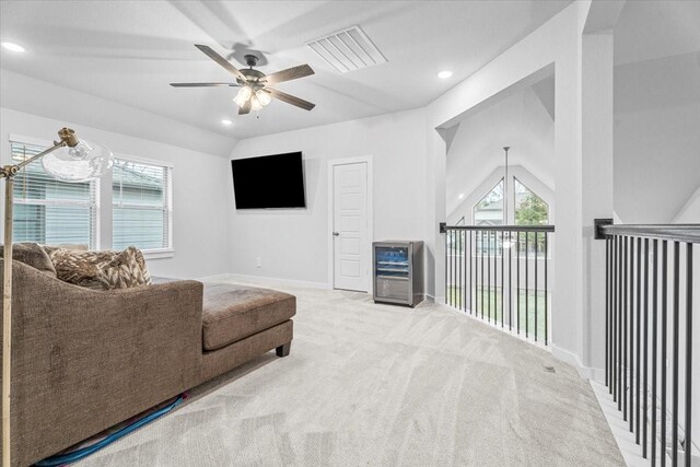 living area featuring ceiling fan, light carpet, and lofted ceiling