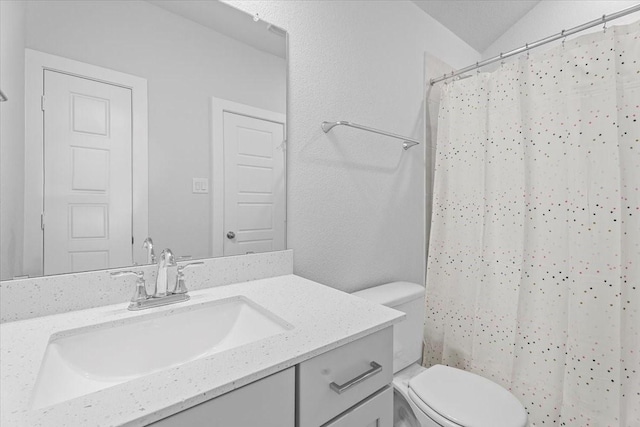 bathroom with vanity, vaulted ceiling, toilet, and a shower with shower curtain