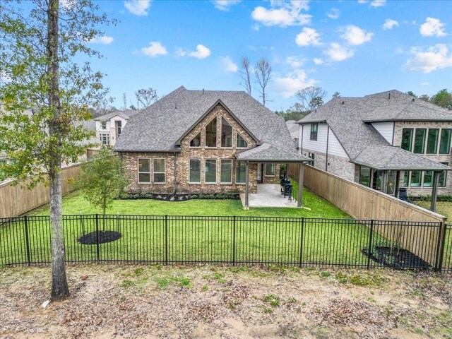 rear view of house with a lawn and a patio