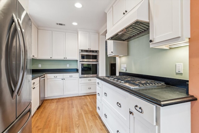 kitchen with stainless steel appliances, custom exhaust hood, light hardwood / wood-style floors, and white cabinets