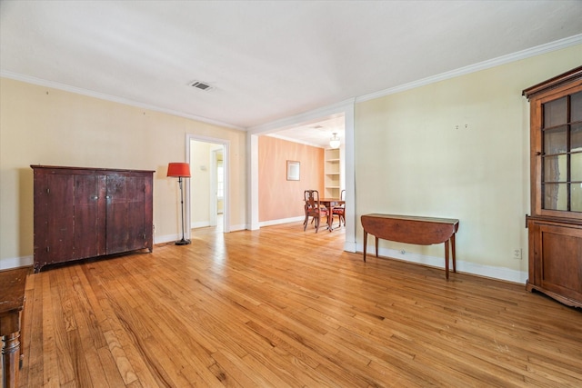 spare room featuring light hardwood / wood-style flooring and ornamental molding