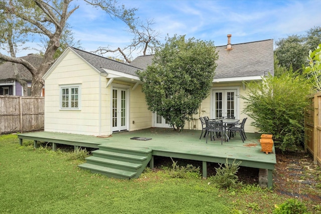 back of property featuring a wooden deck, a yard, and french doors