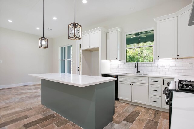 kitchen featuring hanging light fixtures, white cabinets, black appliances, and a kitchen island