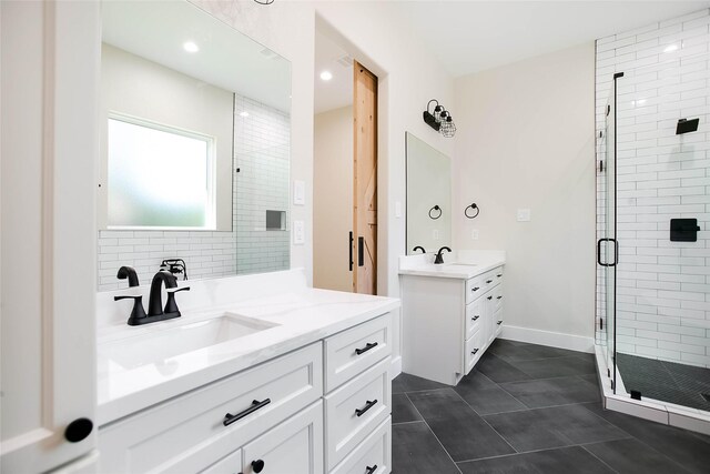 bathroom featuring a shower with shower door, vanity, and tile patterned flooring