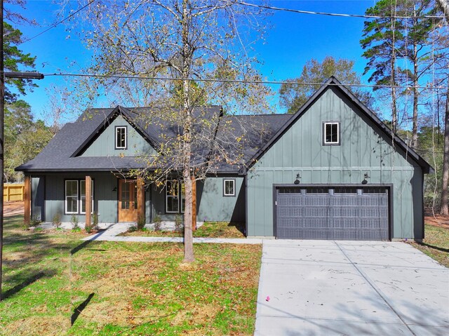 view of front of house featuring a garage, a front yard, and a porch