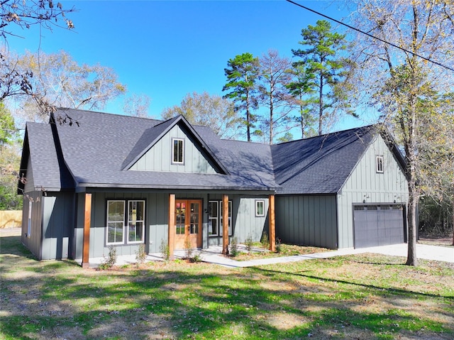 modern farmhouse featuring a front yard, covered porch, and a garage