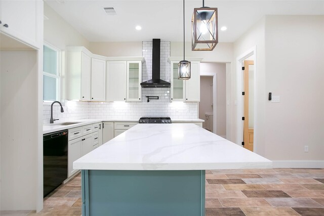 kitchen featuring a center island, dishwasher, wall chimney exhaust hood, white cabinetry, and hanging light fixtures