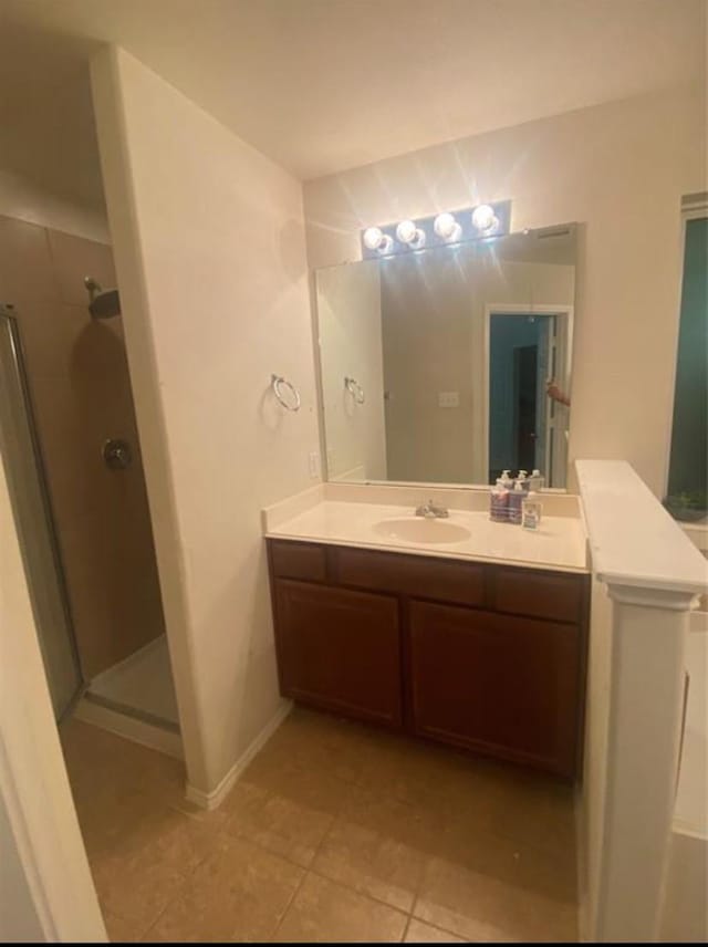 bathroom featuring tile patterned floors, an enclosed shower, and vanity