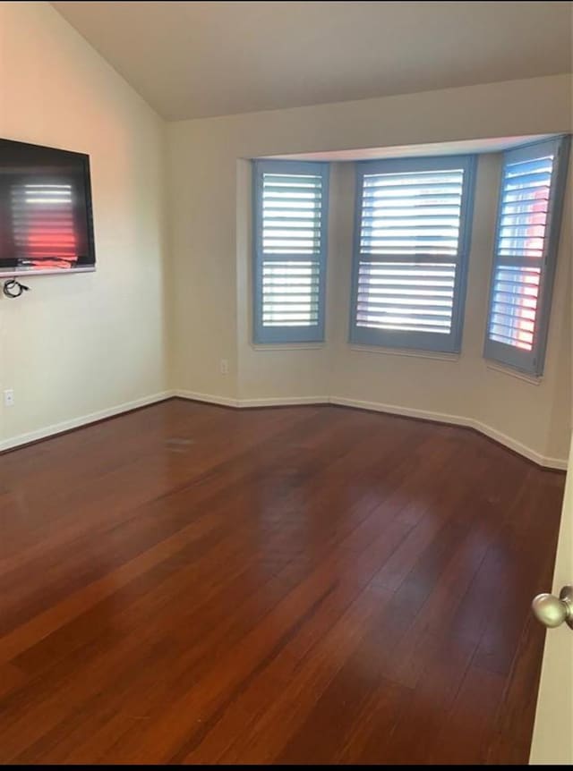 unfurnished room with vaulted ceiling and wood-type flooring