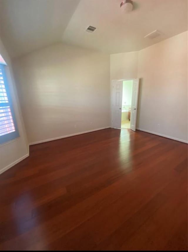 spare room with lofted ceiling and dark hardwood / wood-style flooring