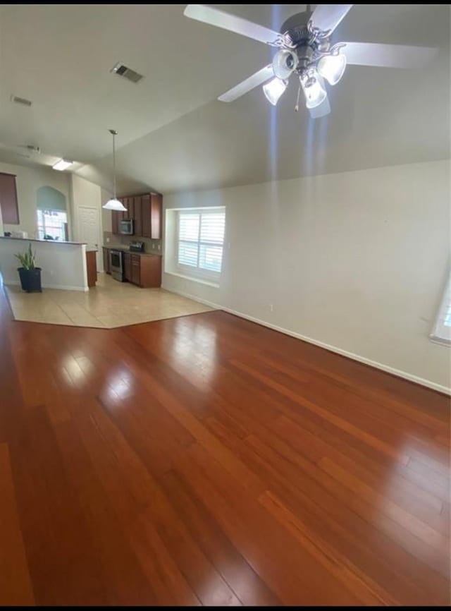 unfurnished living room with ceiling fan, light hardwood / wood-style flooring, and lofted ceiling