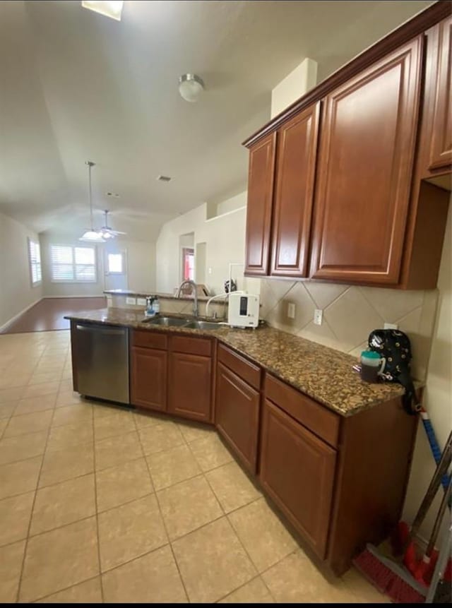 kitchen featuring ceiling fan, light tile patterned flooring, lofted ceiling, dishwasher, and sink