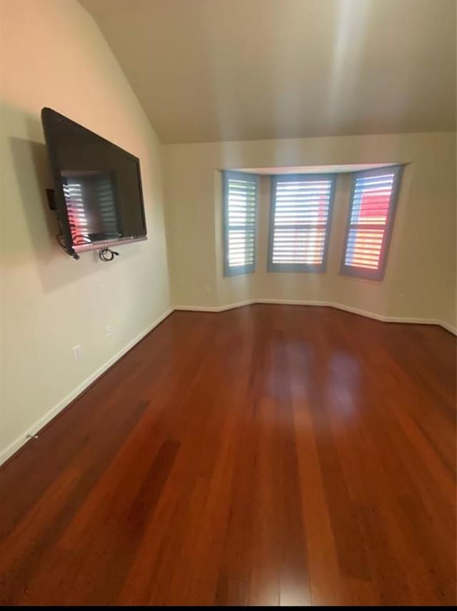 unfurnished living room featuring lofted ceiling and hardwood / wood-style flooring