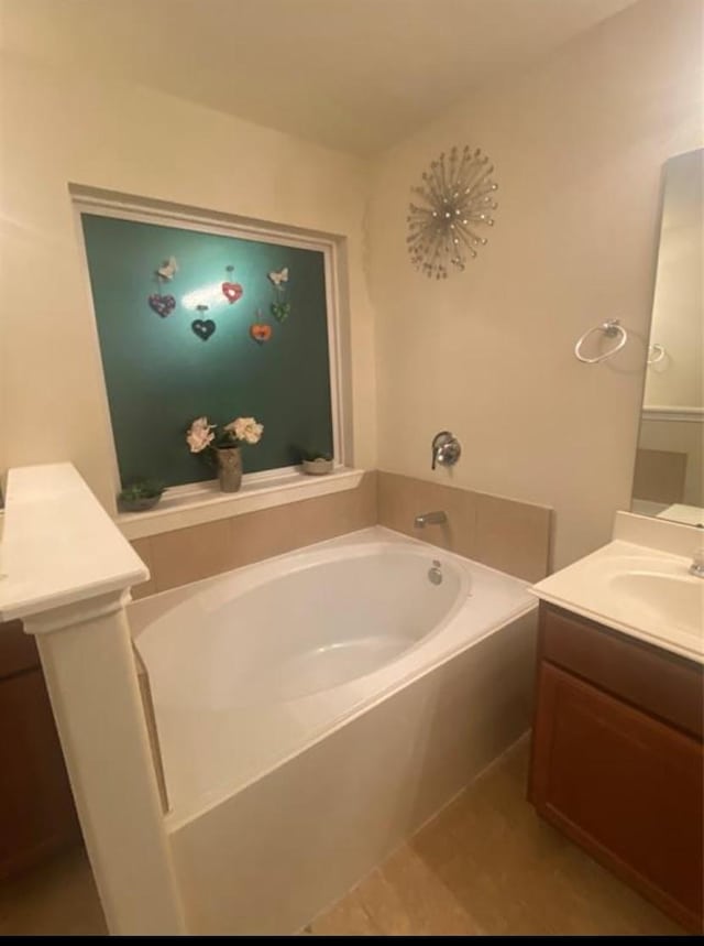 bathroom featuring tile patterned floors, a washtub, and vanity