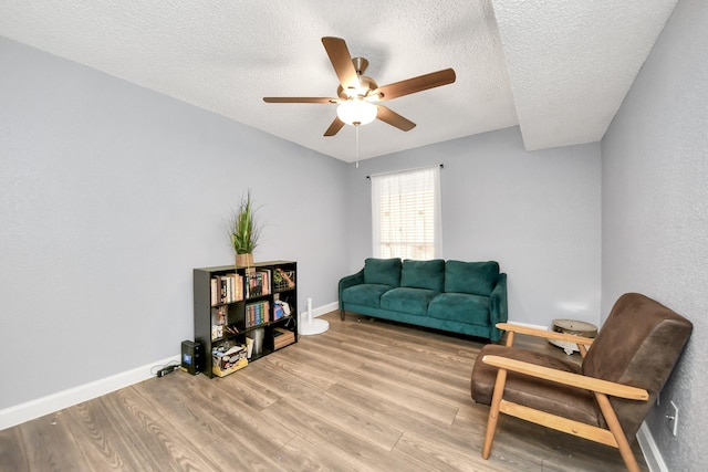 sitting room featuring light hardwood / wood-style floors, a textured ceiling, and ceiling fan