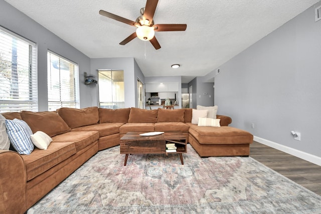 living room with ceiling fan, a textured ceiling, and hardwood / wood-style floors