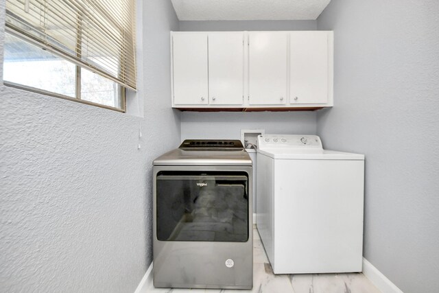 laundry room with cabinets and washing machine and clothes dryer