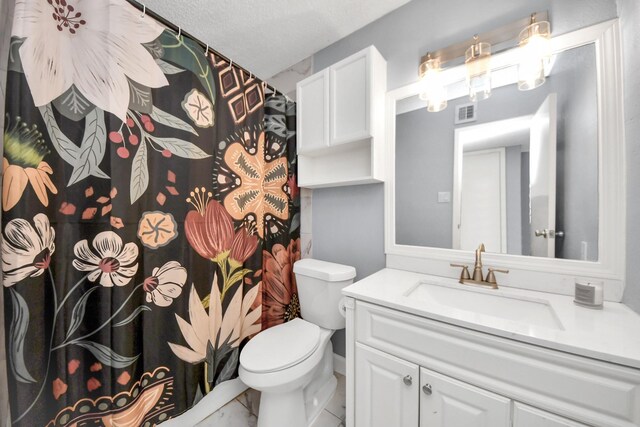 bathroom with toilet, vanity, and a textured ceiling