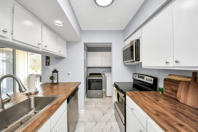 kitchen featuring white cabinetry, appliances with stainless steel finishes, and wood counters