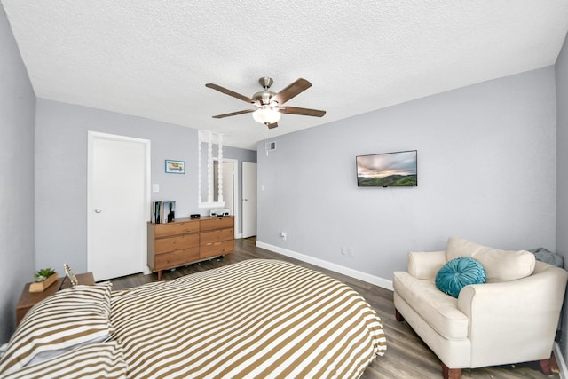 bedroom with ceiling fan, a textured ceiling, and dark hardwood / wood-style flooring