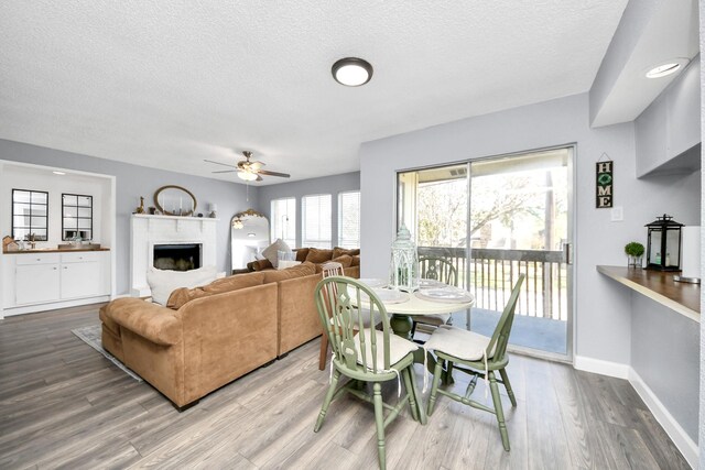 dining room featuring ceiling fan, hardwood / wood-style floors, and a textured ceiling