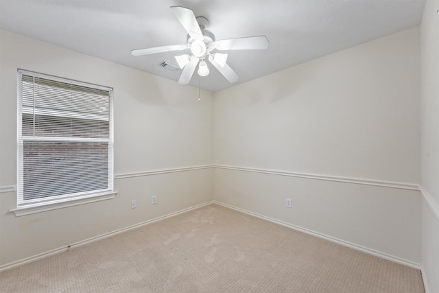 spare room featuring light carpet and ceiling fan