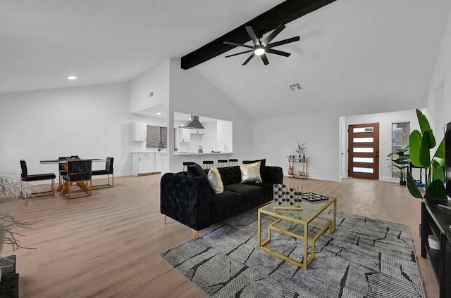 living room with ceiling fan, light wood-type flooring, beamed ceiling, and high vaulted ceiling