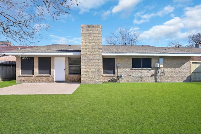 back of house with a lawn and a patio